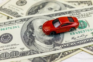 Amerikan doları ve beyaz ahşap arka plan üzerinde minyatür araba modeli. Araç kredisi konsepti