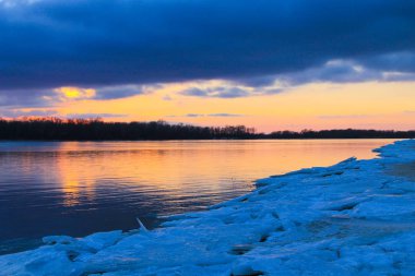 Kışın Dnieper Nehri üzerinde parlak günbatımı