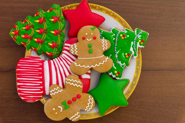Talíř s chutnými vánočními sušenkami na dřevěném stole — Stock fotografie