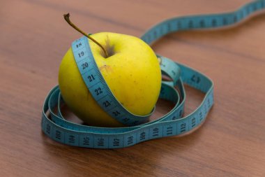 Tahta masada şerit ve yeşil elma ölçüyorum. Diyet ve sağlıklı yaşam tarzı kavramı