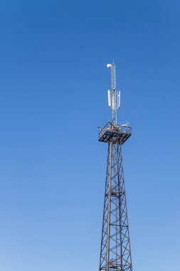 Mobil cep telefonu iletişim mavi gökyüzü karşı antenler ile metal kule
