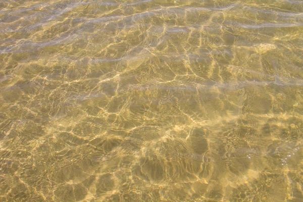 Textur von welligem Meerwasser mit Sandboden als Hintergrund — Stockfoto