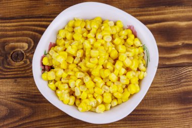 Ahşap masa üzerinde bir kase konserve mısır