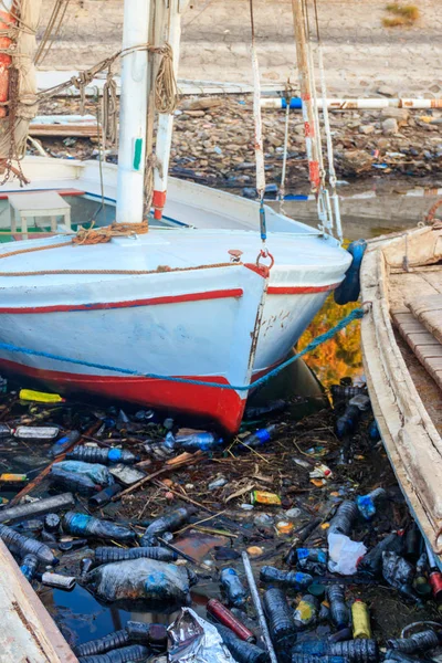 Old boats moored in dirty harbour. Pollution of river, sea, ocean water with waste, plastics garbage. Concept of pollution of ocean, sea and river coastline with plastic trash — Stock Photo, Image