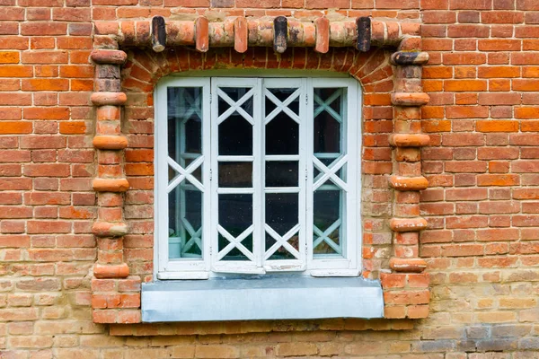 White wooden window on old red brick wall — Stockfoto