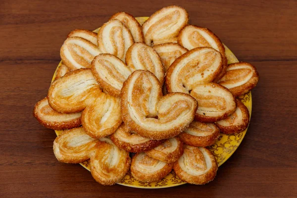 Palmier koekjes-Franse koekjes gemaakt van bladerdeeg (ook wel Palm bladeren, olifant oren of Franse harten) in een bord op houten tafel. Top View — Stockfoto