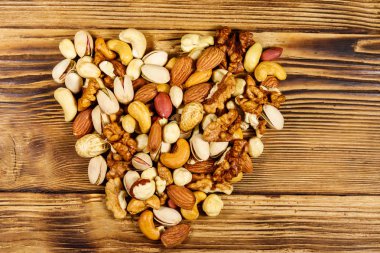 Tahta masada kalp şeklinde karışık fındık yığını. Üst görünüm. 