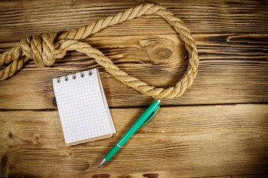 Tahta bir arka planda ölümcül ip ve intihar notu. İntihar kavramı