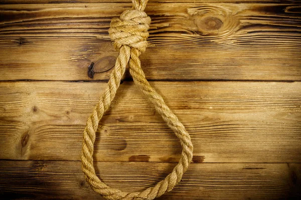 Смертельная петля из веревки на деревянном фоне. Концепция смертной казни или самоубийства — стоковое фото