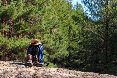 Turist sırt çantası, yürüyüş botları ve çam ormanında şapka. Yürüyüş konsepti