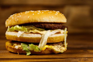 Ahşap masada lezzetli büyük hamburger.