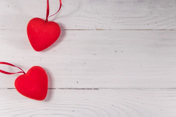 Dos corazones rojos sobre fondo blanco de madera — Foto de Stock