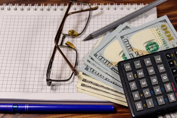 Laptop met dollars, pen, bril en Rekenmachine op houten bureau. Financiële concept. Business accounting — Stockfoto