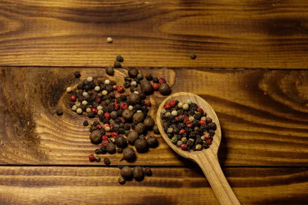 Miscela di grano di pepe in cucchiaio di legno su un tavolo — Foto Stock