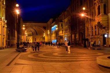 Geceleyin Rusya 'nın St. Petersburg kentindeki Bolshaya Morskaya caddesinde yürüyen turistler