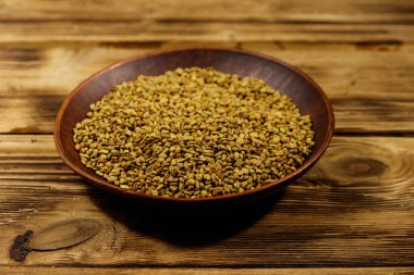 Ahşap masa üzerinde seramik tabakta çemen tohumu