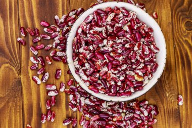 Ahşap masada beyaz eski emaye kase ham böbrek çekirdekleri 