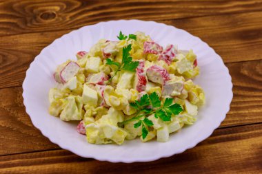 Yengeç saplı salata, tatlı mısır, Çin lahanası, yumurta ve mayonez ahşap masada.