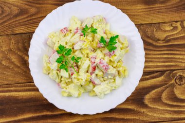 Yengeç saplı salata, tatlı mısır, Çin lahanası, yumurta ve mayonez ahşap masada.