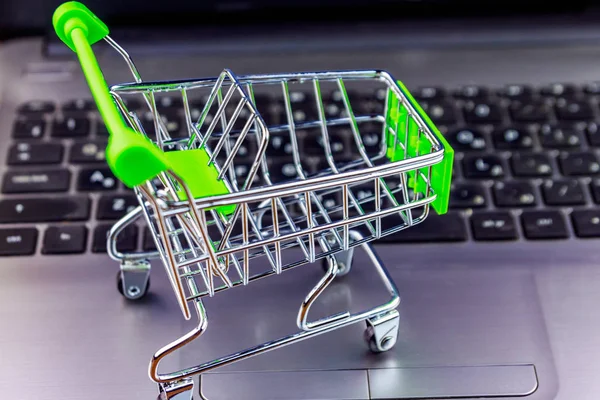 Concepto de compras online. Pequeño carrito de compras en el teclado portátil —  Fotos de Stock