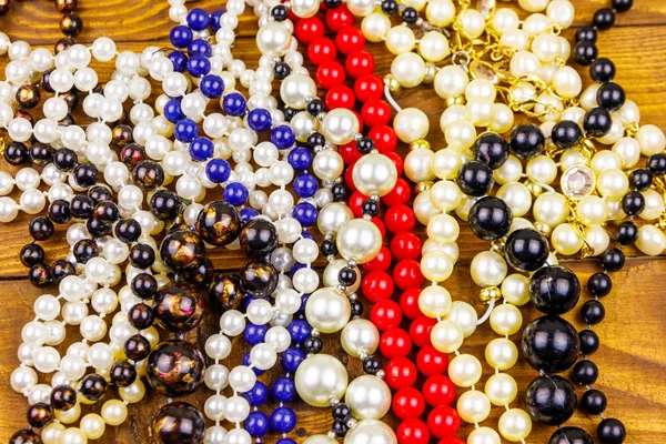 Verschiedene Perlenketten auf Holzgrund — Stockfoto