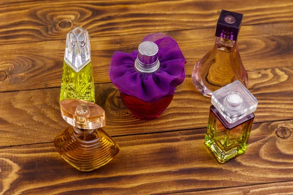 Różne butelki perfum na drewnianym tle — Zdjęcie stockowe