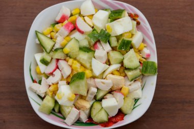 Yengeç sopa, tatlı mısır, salatalık ve ahşap masa üzerinde yumurta salatası. Üstten Görünüm