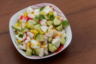 Yengeç sopa, tatlı mısır, salatalık ve ahşap masa üzerinde yumurta salatası. Üstten Görünüm