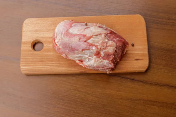 在桌子上的砧板上生猪肉。顶部视图 — 图库照片