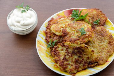 Ahşap masada ekşi kremalı ev yapımı patates krepleri.