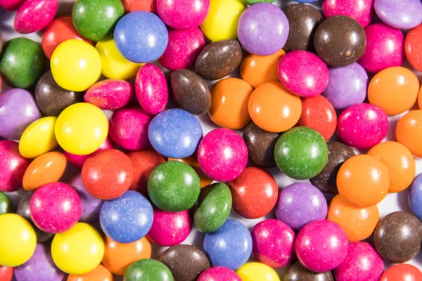 Fond des bonbons colorés en forme de bouton remplis de chocolat — Photo