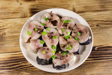 Tahta masada baharatlı dilimlenmiş uskumru. Tabakta tuzlu scomber.