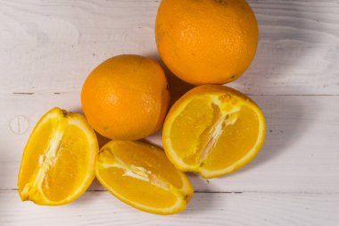 Beyaz ahşap masada taze portakallar.