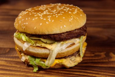 Ahşap masada lezzetli büyük hamburger.