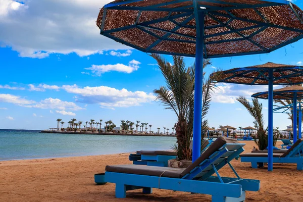 Солнечные зонтики и шезлонги на тропическом пляже. Концепция отдыха, релаксации, отдыха, курорта — стоковое фото