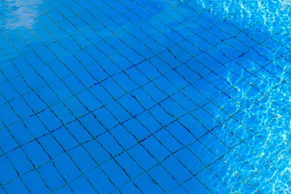 Textura de água na piscina para fundo. Superfície da piscina azul — Fotografia de Stock