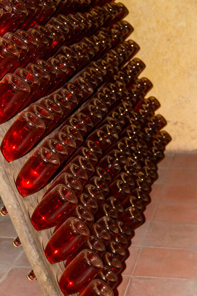 Many wine bottles in wine cellar of winery