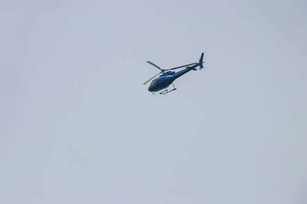 Helikopter vliegt in de blauwe lucht — Stockfoto