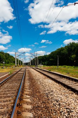 Kırsal alanda doğal demiryolu ve yaz aylarında beyaz bulutlar ile mavi gökyüzü