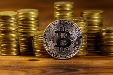 Gümüş bitcoin ve ahşap arka plan demir yığınları