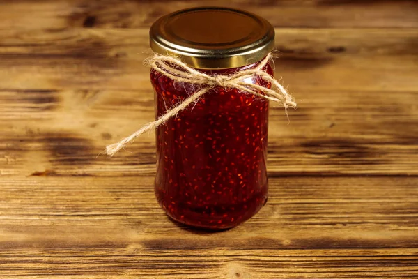 Malinový džem ve skleněné sklenici na dřevěném stole — Stock fotografie