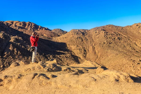 Junger Mann beim Fotografieren der Berge am Roten Meer in der arabischen Wüste, Ägypten. Konzept der Reisefotografie — Stockfoto