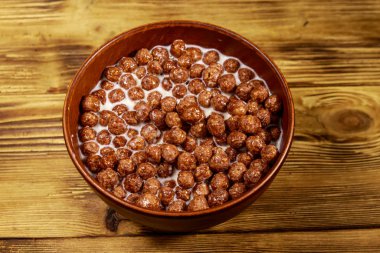 Tahta masadaki kasede sütlü tahıl gevreği.