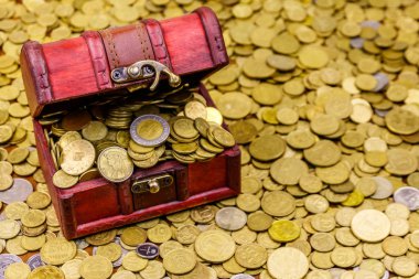 Altın madeni paralarla dolu antika hazine sandığı.