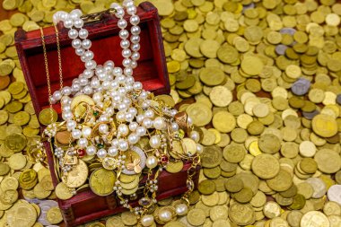 Altın sikke ve mücevherlerle dolu eski bir hazine sandığı.