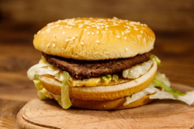 Ahşap masada lezzetli büyük hamburger.