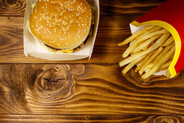 Hambúrguer grande e batatas fritas na mesa de madeira — Fotografia de Stock
