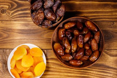 Kurumuş kayısılar ve ahşap masada meyveler. Üst görünüm