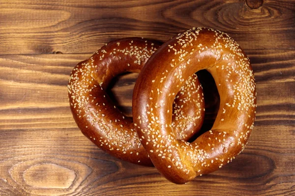 Bagels with sesame seeds on wooden table — Stock Photo, Image