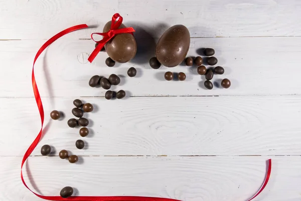 Composizione pasquale con uova di cioccolato su fondo di legno bianco — Foto Stock